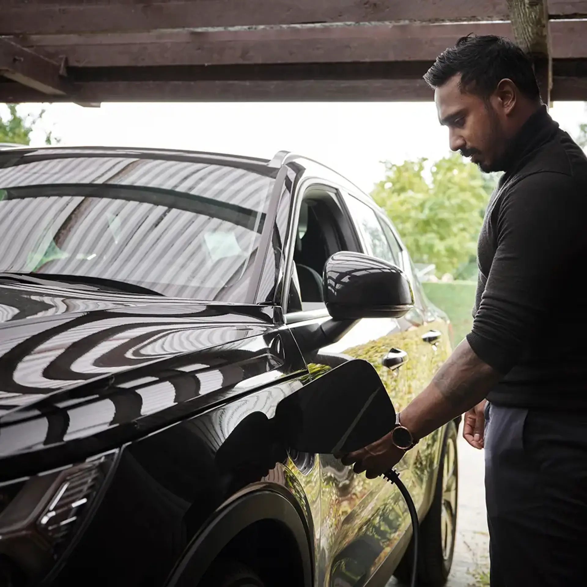 Mand som lader sin elbil